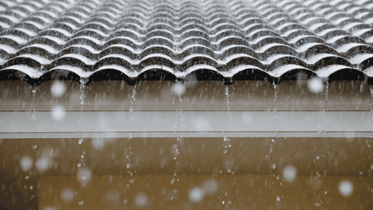 A tile roof is under torrential rainfall during the cold winter months.