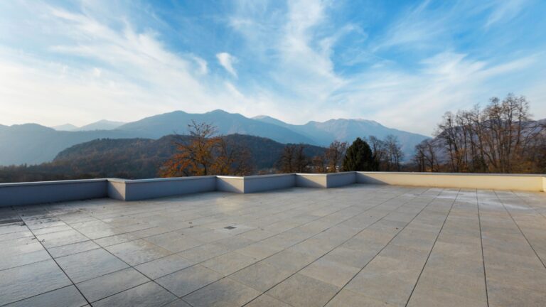 A large flat roof with a view of the hills and trees.